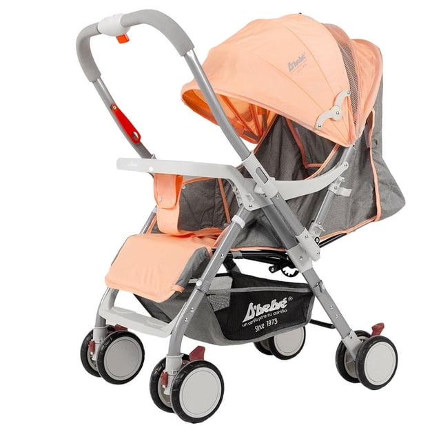 carriola de manubrio reversible baby buggy baby bm beige rosa 4 con asiento reclinable, capota rosa plegable y repisa frontal para biberón, cinturón de 5 puntos, canastilla inferior amplia y freno en las cuatro llantas; vista 3/4 lateral; suele usarse también para transportar pañales y accesorios en salidas con el bebé.