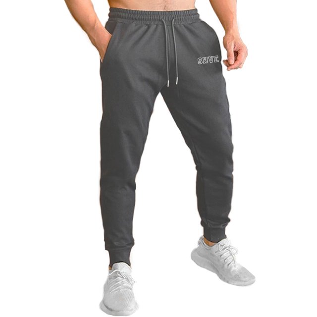 pants jogger para hombre shendy vendy deportivo slim fit elástico Gris Oxford, vista frontal centrada de jogger slim con cintura elástica acanalada y cordón funcional con puntas plateadas, puños inferiores ajustados, bolsillos laterales visibles y logo de marca en la pierna; adecuado para entrenamiento ligero o uso casual, a la vez que sirve como opción cómoda para viajes cortos.
