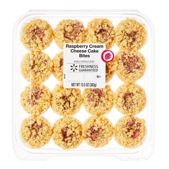 cake bites freshness guaranteed rapsberry cream cheese 383 g envase plástico transparente con 16 pastelitos pequeños dispuestos en 4x4, cada uno con migas doradas y relleno rosado de frambuesa visible; etiqueta central blanca muestra 'Raspberry Cream Cheese Cake Bites' y marca Freshness Guaranteed, net wt 13.5 oz (383 g).
