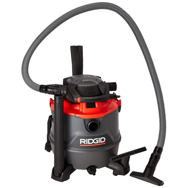 aspiradora ridgid rt1600m sólidos y líquidos doble herramienta manguera profesional ergonómica rueda RIDGID 16 galones, vista frontal 3/4 de aspiradora naranja y gris con tambor de polipropileno de 2 piezas, tapa superior negra, manguera corrugada profesional de 8 ft (2.4 m), boquilla plana y tubo de extensión visibles, ruedas giratorias 360 y asas de transporte; a menudo usada también para limpiar restos de taller o escombros ligeros.