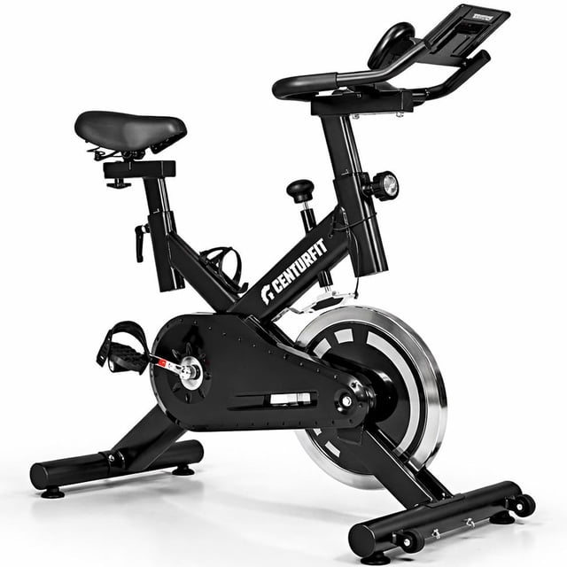 bicicleta estatica fija spinning centurfit rueda silenciosa fitness Bicicleta de spinning Centurfit vista lateral, estructura de acero negra con rueda de inercia plateada de 36 cm (7 kg), resistencia con zapatas de fieltro, asiento con muelles y manubrio ajustable, pedales con correas, soporte para celular/tablet y portabotellas; diseño compacto y silencioso para entrenar en casa, también apta para sesiones de intervalos en espacios reducidos.