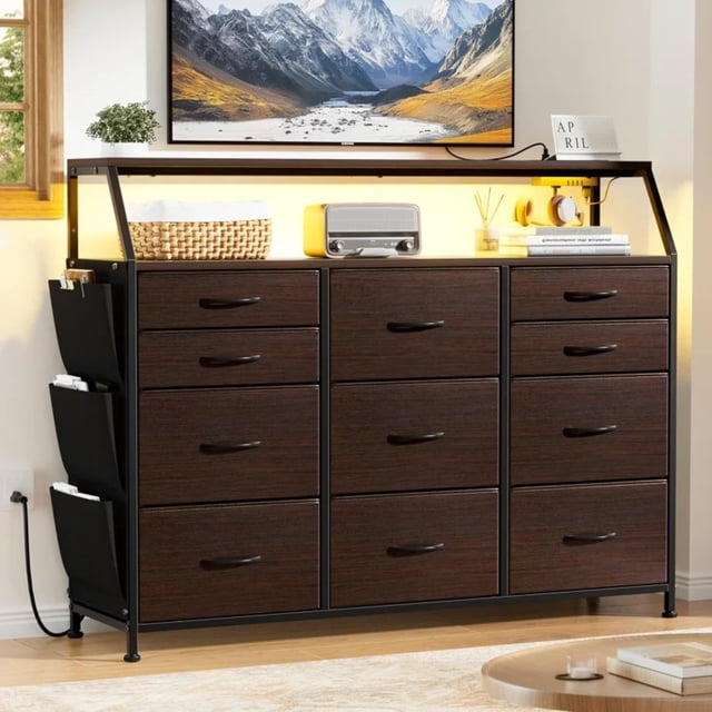 comoda cajonera para recamara -11 cajones de tela con parte superior de madera y marco de acero plegable - mueble organizador con cajonera para ropa - luces led - estación de carga. Cajonera color chocolate FABATO con 11 cajones en tres columnas, tablero superior de MDF y marco de acero negro plegable; tiradores negros y acabado tipo madera; estantes superiores con luces LED RGB ajustables, bolsillos laterales organizadores, patas metálicas ajustables y sistema antivuelco; estación de carga con puertos AC, USB y Tipo C. También adecuada como superficie de apoyo en recámaras pequeñas.