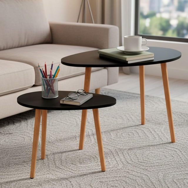 set de 2 mesas minimalistas ovaladas mesa auxiliar lateral mesita moderna minimalista para sala de estar dormitorio balcón mesa de centro mesita de noche grande (negro) Conjunto de dos mesas ovaladas negras con tapas MDF y patas cónicas color madera, vista 3/4 frontal; mesa baja y mesa alta juntas sobre alfombra frente a sofá, superficies con taza, libros y portalápices; ligeras y fáciles de mover, suelen usarse también como mesitas auxiliares para trabajo o lectura.