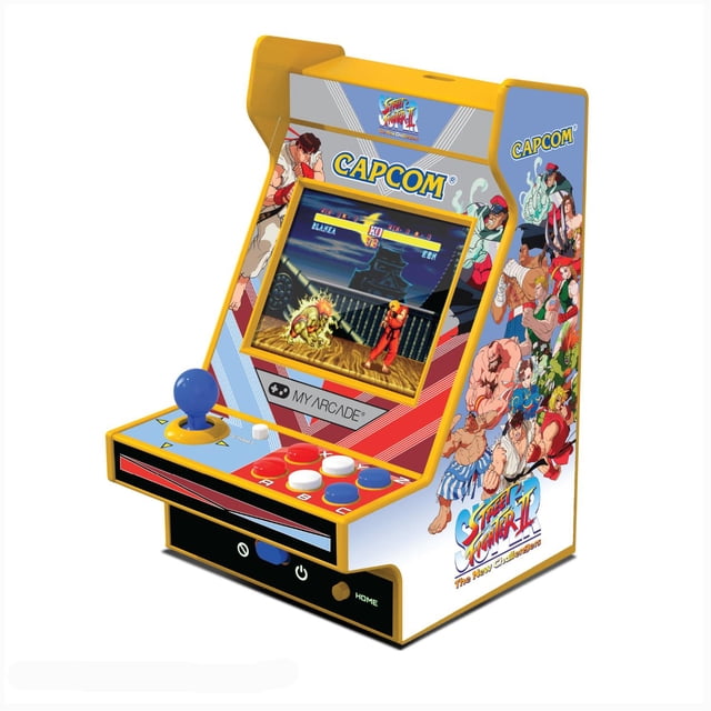 arcade retro 4.8 super street fighter ii 2 juegos en 1 naranja my arcade mini gabinete retro naranja con pantalla a color de 2.4 pulgadas frontal, joystick azul y cuatro botones blancos y rojos, artwork lateral y frontal con logo Capcom y personajes de Street Fighter II, altavoz trasero con controles de volumen visibles y puerto USB-C frontal; suele usarse también como display de colección por su tamaño compacto.