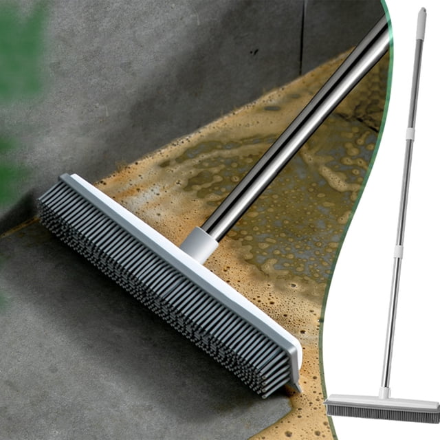 cepillo de escoba y piso de empuje 2 en 1 con escobilla de goma incorporada | Cabezal en 3/4 empujando líquido sobre piso, cerdas de silicona densas y borde de goma TPR visibles; mango de acero inoxidable de 120 cm/47,2" en ángulo de 45°; fondo de concreto y recorte del producto completo a la derecha. Para uso en interiores y exteriores, recoge cabello y escombros; también suele usarse para enjuagar y empujar agua en garajes o terrazas.