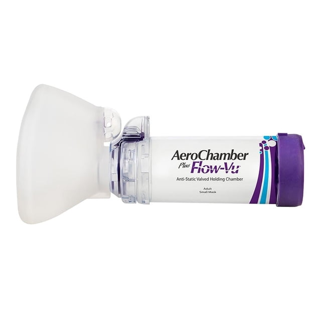 cámara espaciadora aerochamber flow vu con mascarilla adulto para mujer, diseño aerodinámico blanco; vista lateral de la cámara transparente de 149 ml con fragmentador interno, válvulas inspiratoria y espiratoria sensibles, mascarilla sin látex con sello ajustado y marca AeroChamber visible.
