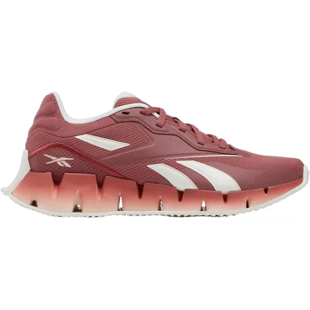tenis reebok zig dynamica 4 para mujer 100033868 terracota 23.5 perfil lateral de tenis deportivos terracota con malla textil transpirable y refuerzos sintéticos; suela Zig de goma escalonada en degradado terracota a rosa con ranuras para flexión y agarre, logo Reebok en costado y talón; pensados para correr y uso diario, también suelen usarse para entrenamiento ligero.
