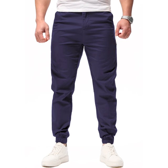 pantalon jogger para hombre shendy vendy slim fit stretch con cordon Azul Oscuro, vista frontal de cuerpo parcial que muestra ajuste slim y tiro medio; cintura con cordon visible, puños elásticos en tobillo y textura de tacto suave; modelo con tenis blancos sobre fondo blanco. Apto también para uso casual diario o para vestir en viajes cortos por su corte slim.