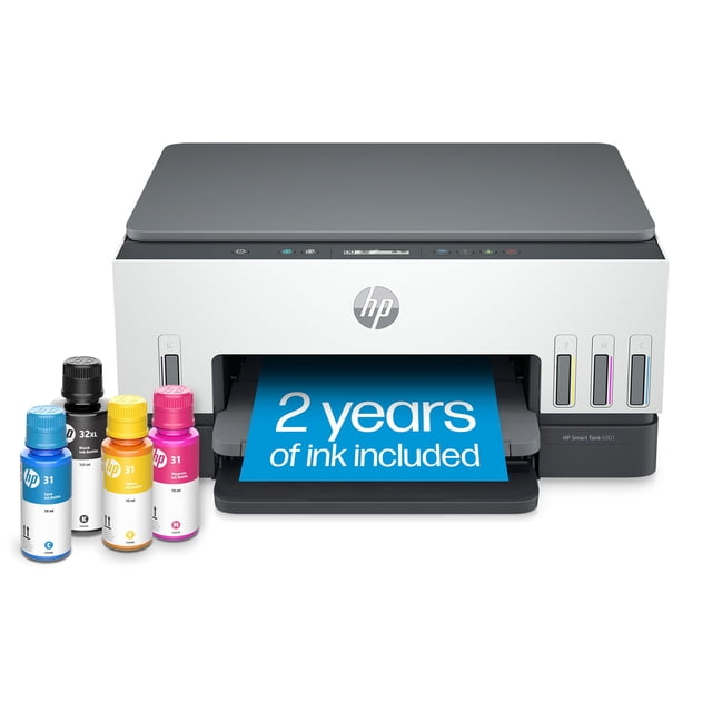 impresora inalámbrica hp smart -tank 6001 sin cartucho vista frontal centrada de la impresora blanca todo en uno con tapa de escáner gris, bandeja de salida con hoja azul que indica 2 años de tinta incluida; panel frontal con logotipo HP y depósitos visibles en cian, magenta, amarillo y negro y botellas de tinta a la izquierda; admite impresión móvil, escaneo y copias en volúmenes altos y a menudo se usa para imprimir tareas escolares y proyectos domésticos.