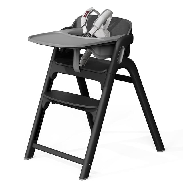 momcozy dinerpal silla de madera para bebés, trona convertible, con bandeja de grado alimenticio, ajustable trona negro medianoche en vista frontal 3/4; madera de haya certificada, respaldo ligeramente curvado para soporte postural, asiento con 2 posiciones y reposapiés con 7 niveles, bandeja extra ancha desmontable apta para lavavajillas (23.5 cm) y arnés de cinco puntos desmontable; patas en A con topes de silicona antideslizantes. También suele usarse como torre de aprendizaje o taburete conforme crece el niño.