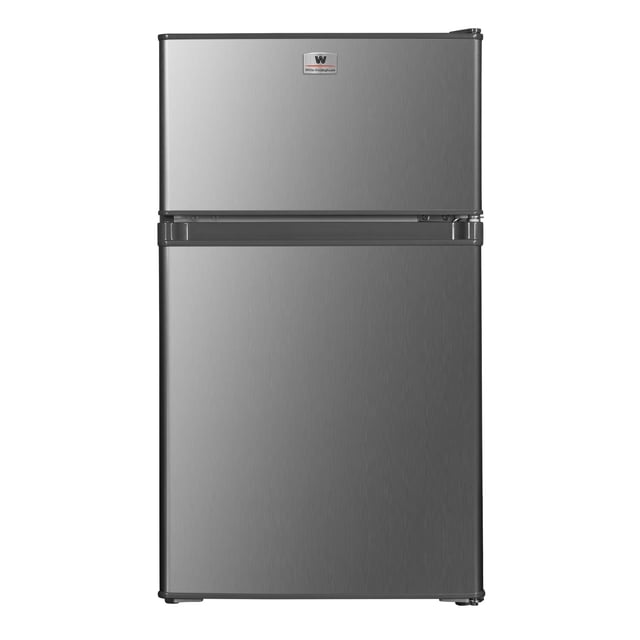 white westinghouse refrigerador frigobar 3 pies 85l modelo wwcr3085lhs con congelador independiente y dos puertas, vista frontal en acabado acero VCM con logo White‑Westinghouse en la puerta superior; incluye control mecánico, puerta reversible, luz interior, charolas de cristal templado, patas ajustables y condensador interno; ideal para oficinas o recámaras y también adecuado para enfriar bebidas en espacios pequeños.