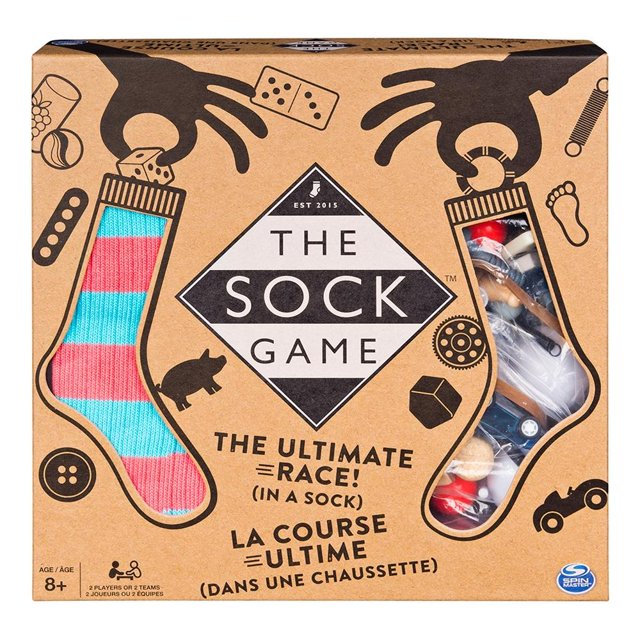 el juego del calcetín spin master 1 pza juego de mesa multicolor, empaque frontal con ilustración de calcetines y ventana que muestra accesorios plásticos; texto central "The Sock Game", incluye 1 tablero, accesorios e instrucciones, diseñado para 2 o más jugadores y para fomentar la búsqueda de objetos dentro de un calcetín en reuniones familiares.