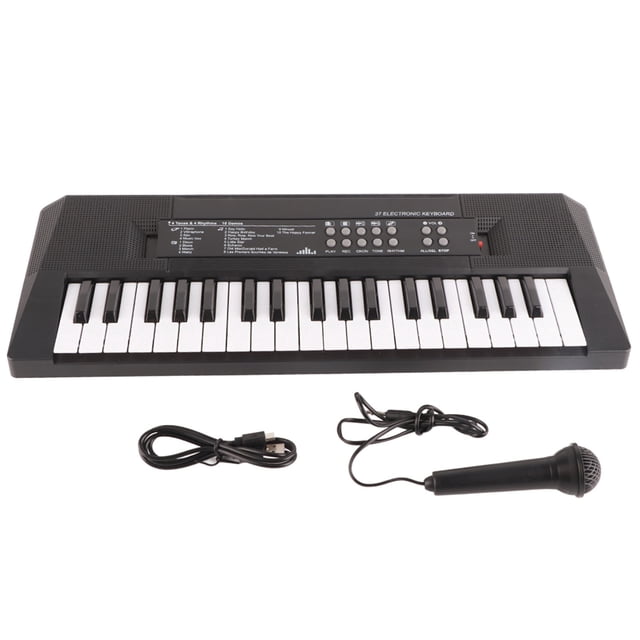 teclado musical, teclado eléctrico piano de 37 teclas piano eléctrico artesanía excepcional Teclado eléctrico de 37 teclas blanco y negro, vista frontal centrada con teclas blancas y negras, panel superior con botones de control visibles, incluye micrófono con cable y cable USB; funciona con 3 pilas AA (no incluidas) o alimentación por USB. Suele usarse también para prácticas y grabaciones caseras.