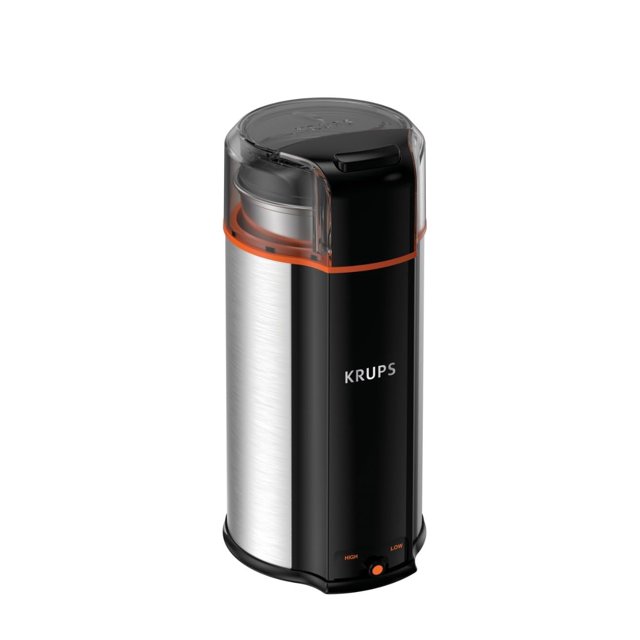 molinillo de café krups ultimate silent vortex 90 ml 240 w plateado — Vista frontal en 3/4 de un molinillo cilíndrico plateado y negro con logo KRUPS, tazón superior transparente extraíble con borde naranja y tapa, base negra con botón de dos velocidades (high/low). Diseño ovalado visible; apto para moler granos y hierbas y molido silencioso según especificación del producto.