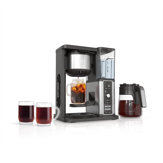 cafetera ninja cm371 hot & iced xl con cerveza fría para 12 tazas negra, vista frontal 3/4 con jarra de vidrio de 12 tazas a la derecha; depósito de agua extraíble transparente con graduación y bandeja central sosteniendo un vaso con café con hielo; panel frontal con botones para 4 estilos (clásico, rico, sobre hielo, frío) y selector de 8 tamaños, incluye filtro permanente y cuchara medidora; a menudo se usa también para preparar porciones individuales frías o calientes para llevar.