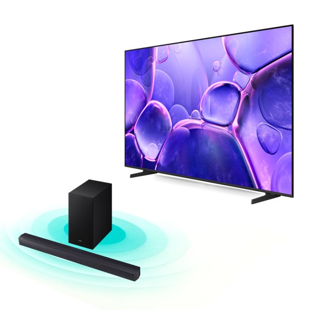 combo tv 65'' samsung crystal u8200f 4k smart tv (2025) + barra de sonido 2.1 ch subwoofer b-series hw-b450f (2025) negro Televisor Samsung 65'' Crystal U8200F 4K Smart TV Tizen en vista frontal derecha con biseles delgados y peanas en L; pantalla plana muestra imagen púrpura. Delante, barra de sonido negra 2.1 ch HW‑B450F y subwoofer rectangular negro sobre fondo claro; acabado mate visible, conectividad Wi‑Fi y Bluetooth indicada en especificaciones, y tecnologías listadas: Crystal Processor 4K, PurColor, HDR y Dolby Atmos. A menudo se utiliza también para reproducir música en streaming desde el móvil mediante Music Frame.