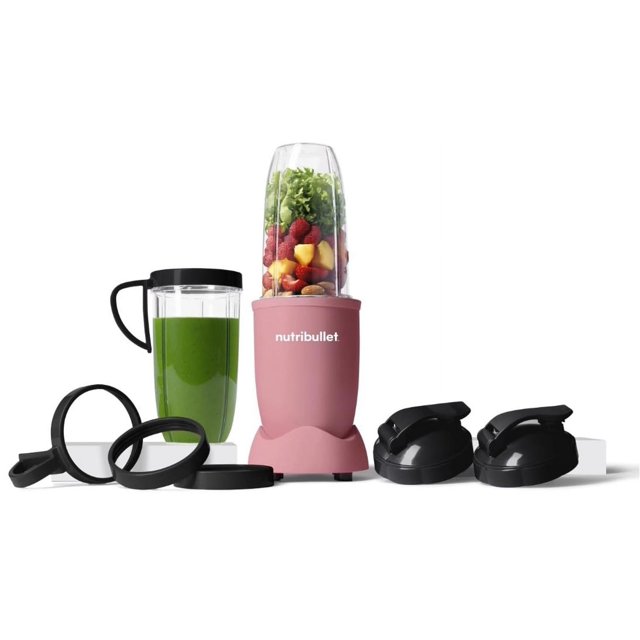 nutribullet pro 13 piezas licuadora de alimentos 900 w rosa suave mate vista frontal de la base rosa mate con vaso alto transparente lleno de frutas y hojas verdes, vaso para llevar con tapa negra y vaso con smoothie verde, anillos de sellado y tapas giratorias negras dispuestos alrededor; ideal para preparar batidos diarios y adecuada para llevar bebidas en viaje.