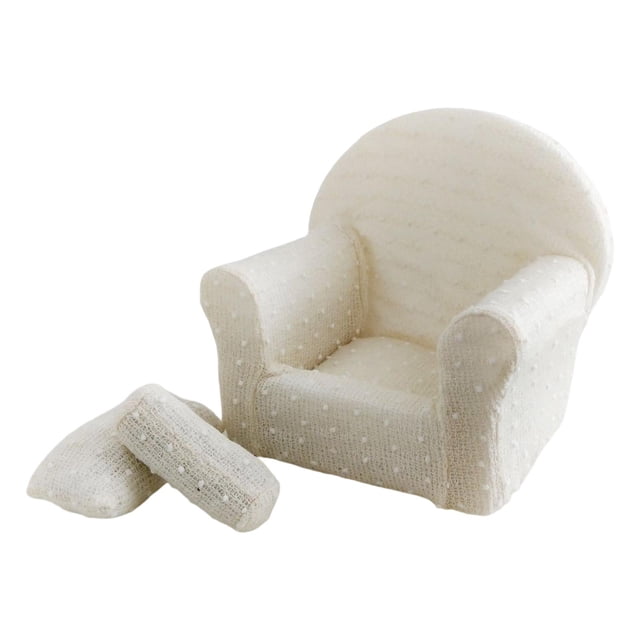fotografía de bebé sofá pequeño sofá asiento fondo decorativo con cojín almohada beige. Sofá de espuma beige para recién nacidos, vista frontal centrada con respaldo redondeado y apoyabrazos curvos, textura de punto visible y dos cojines frontales; accesorio de estudio para sesiones newborn y baby shower, altura trasera 29 cm, adecuado para posar bebés de 0 a 3 meses.