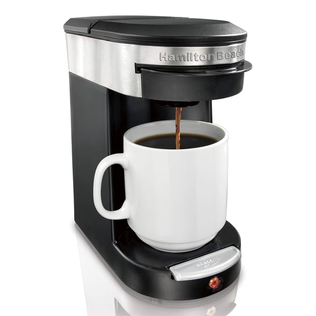 hamilton beach 49970-mx cafetera personal ejecutiva, 1 taza, 350 ml negra; vista frontal 3/4 de cafetera de una taza con frente de acero inoxidable y cuerpo negro, café goteando en una taza blanca sobre la plataforma; canasta con filtro permanente visible y botón de encendido frontal con indicador y apagado automático; fondo blanco de estudio; adecuada para preparar hasta 350 ml en modo fuerte o regular.