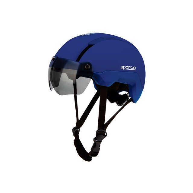 sparco casco bicicleta luz led trasera y visera magnética aerodinámica azul, vista 3/4 frontal centrada con visera magnética semi‑ahumada colocada, carcasa de policarbonato con 16 orificios de ventilación visibles, correas de barbilla y hebilla de ajuste, luz LED trasera integrada y logo Sparco lateral en blanco; también apto para uso urbano y transporte compacto en viajes.