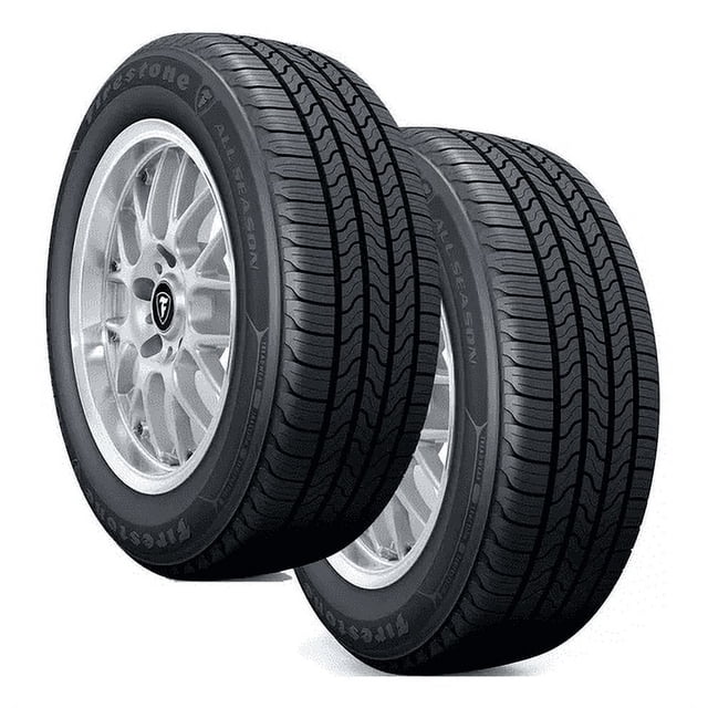 paquete de 2 llantas 215/70 r15 98t kit de firestone all season, vista 3/4 de dos llantas negras montadas en rines plateados; banda de rodamiento con canales de evacuación visibles y marcaje 215/70R15 98T en el costado. Apto para condiciones secas y mojadas; también suele usarse para reemplazo de neumáticos de turismo.