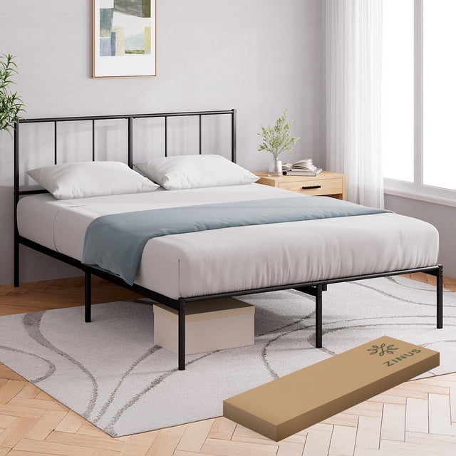 base de cama con cabecera metálica queen size zinus florence. fácil armado, vista frontal en cuarto minimalista; estructura negra mate con cabecera de barras verticales y patrón geométrico rectangular, listones metálicos horizontales, 26.4 cm de altura libre mostrando caja de almacenamiento debajo y caja de envío Zinus; también adecuada para guardar ropa de temporada.