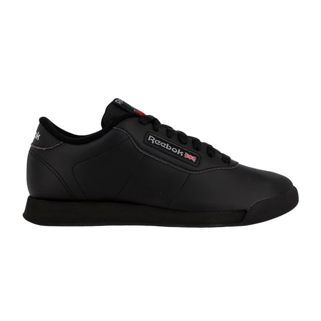 tenis reebok unisex princess negro j95361 Tenis Reebok Princess negros en vista lateral izquierda, capellada de piel sintética lisa con sistema de ajuste con cordones negros, lengüeta y forro interior de polar, etiqueta Reebok con bandera en el lateral, mediasuela de EVA con amortiguación y suela exterior de caucho negra. Su tamaño compacto los hace adecuados para uso casual diario.