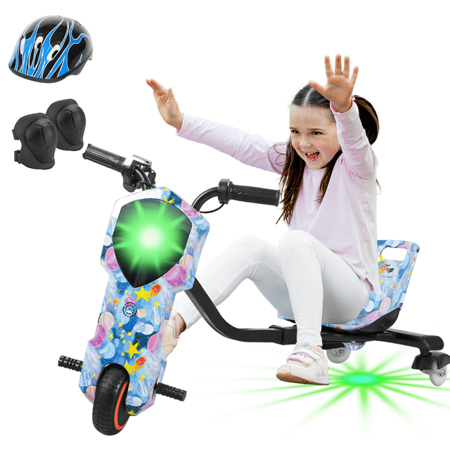 triciclo eléctrico honey whale mz-008 azul 3/4 frontal con niña sentada, asiento y manubrio negros; carrocería azul con estampado de estrellas y burbujas, rueda delantera negra con aro naranja, luz frontal verde encendida, chasis negro y ruedas traseras giratorias; incluye casco y rodilleras. Especificado para niños desde 5 años, 3 velocidades, velocidad máxima 18 km/h y capacidad 60 kg; a menudo usado para juegos en interiores y exteriores.