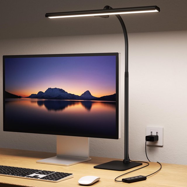 lámpara led de escritorio kary para oficina doméstica, altura ajustable — vista frontal 3/4 de lámpara LED negra con barra horizontal iluminada, cuello gooseneck ajustable y cardán de 270°, base rectangular con control en cable y cable USB enchufado a la pared, colocada en escritorio de madera junto a monitor; adecuada para lectura y trabajo.