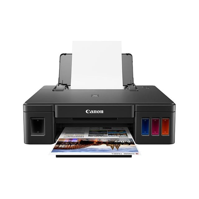 impresora de tinta continua canon pixma g1110, tinta continua vista frontal centrada; cuerpo negro rectangular con bandeja posterior cargada de hojas, salida frontal con una hoja impresa a medio salir, tanques translúcidos de tinta visibles en el lado derecho (azul, magenta, amarillo) y depósito en el lado izquierdo, superficie superior lisa con botones visibles. Apto para uso doméstico y de oficina; a menudo se usa también para imprimir fotografías y documentos en volumen moderado.
