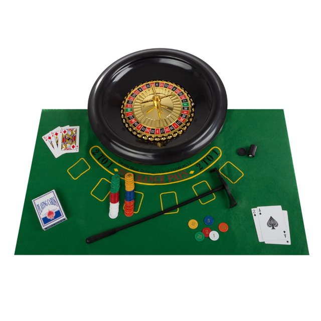 juego de ruleta Trademark Poker de 16 pulgadas con mesa y fichas, vista cenital centrada de una rueda de ruleta negra de 16 pulgadas sobre fieltro verde reversible (lado ruleta/ruleta visible), pilas de fichas de colores numeradas del set de 120 fichas, bola de ruleta visible, rastrillo y marcador negros, y dos barajas de cartas con cartas repartidas; detalle de textura de fieltro y presentación estilo casino ideal para noches de juego en casa.