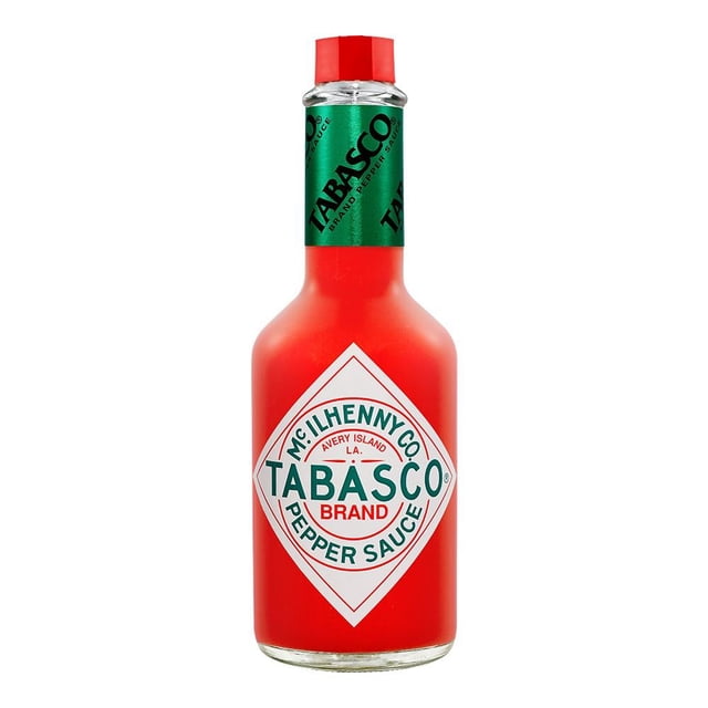 salsa tabasco 355 ml botella de vidrio frontal con salsa picante roja, etiqueta rombo blanca con TABASCO y tapa roja, sello verde en el cuello; empaque práctico para condimentar en despensa. A menudo se usa también para realzar tacos y marinados.