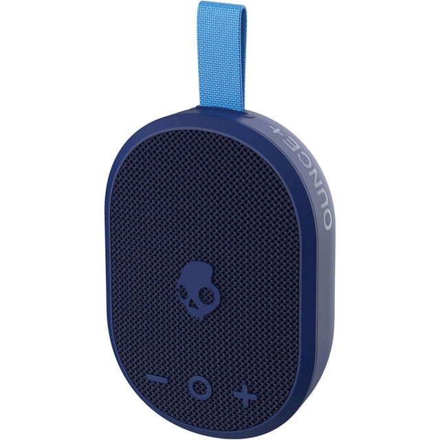 bocina mini inalámbrica skullcandy azul, vista 3/4 frontal con correa integrada; diseño ovalado con rejilla texturizada y logo de calavera en el centro, botones de volumen y reproducción en la superficie, lateral con marca OUNCE+ y puerto USB-C visible, portátil compatible con Bluetooth v5.3; ideal para llevar música en viajes cortos o paseos.