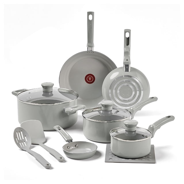 t-fal juego de sartenes y ollas antiadherentes refresh de cerámica, 12 piezas, fabricado sin pfoa y ptfe, apto para horno, c486sc64 gris: vista frontal con sartén grande (Thermo-Spot rojo en el centro) y pequeña mostrando base estriada, cacerola grande con tapa de vidrio ventilada, cacerola mediana y cazo pequeño con tapas, utensilios (espátula ranurada y paleta) y salvamanteles; asas ergonómicas y revestimiento interior cerámico antiadherente visibles; apto para horno hasta 300 °F, no compatible con inducción; el tamaño compacto de las piezas pequeñas suele ser ideal para calentar salsas o porciones.