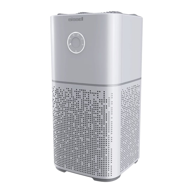 purificador de aire bissell air180, filtro hepa para el hogar, color gris vista frontal 3/4 del purificador gris con control circular en la parte superior; carcasa perforada 360° para entrada de aire y rejilla superior para salida; filtración en 3 etapas con prefiltro, filtro de carbón activado y HEPA médico que captura humo, polvo, polen y caspa de mascotas; cubre hasta 457 ft² con tres cambios de aire por hora; ideal para dormitorios y oficinas en casa.