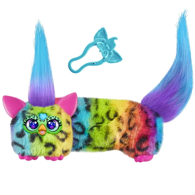 peluche electrónico Furby DJ Furblets Rain-Bow-Kat Mini multicolor, vista frontal centrada de un mini peluche alargado con estampado de leopardo arcoíris, ojos digitales brillantes, nariz y patas rosas, gema de corazón azul en la frente, mechones de pelo morado-azul en ambos extremos y clip llavero azul desmontable; reproduce música y frases en Furbish, y es adecuado para sujetarlo a una mochila como juguete de viaje.