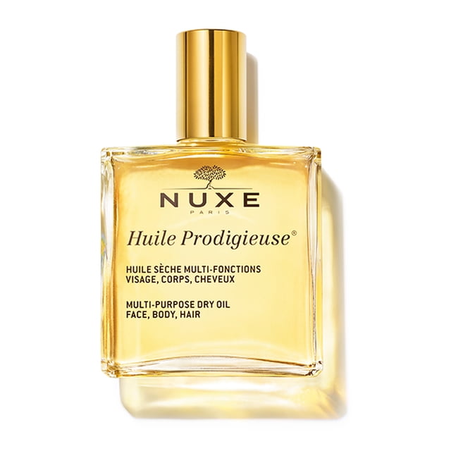 aceite seco nuxe huile prodigieuse 50 ml frasco rectangular de vidrio con tapa dorada y aceite dorado visible, etiqueta frontal con logo NUXE y texto multiuso para rostro, cuerpo y cabello, vista frontal centrada sobre fondo blanco; también suele usarse como aceite corporal hidratante para masaje ligero.