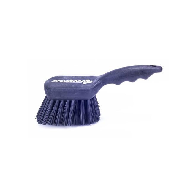 escobeta multiusos el castor mango corto poliéster 3102 gris, vista 3/4 con mango corto ergonómico; cerdas de fibra de poliéster negras de 1 ¾ (4.44 cm) sobre base rectangular con logotipo visible, fondo blanco. Recomendada para limpieza general; también suele usarse para fregar áreas exteriores pequeñas. No usar en contacto con alimentos ni en áreas de altas temperaturas.