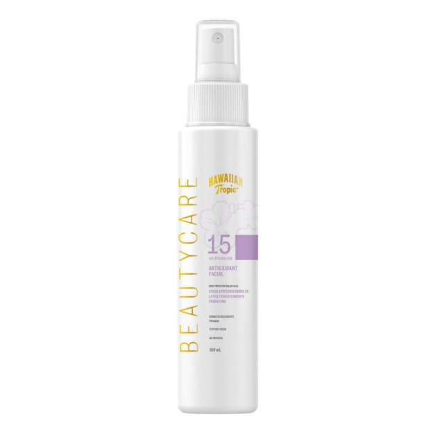 hawaiian tropic antioxidant facial fps 15 previene daños y envejecimiento spray facial en envase blanco cilíndrico con atomizador, texto dorado 'BEAUTYCARE', logo Hawaiian Tropic, banda lila con número 15 y especificación 100 ml; protector solar facial en formato spray, a menudo usado para retoques rápidos durante el día.