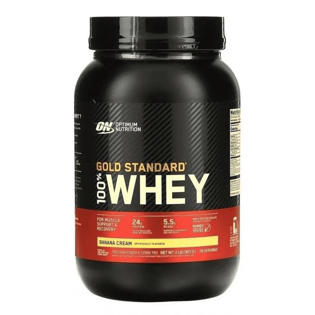 optimum nutrition gold whey standard 2 lbs banana cream tarro frontal de proteína en polvo crema de plátano, etiqueta negra y roja con '100% WHEY' en grande, indica 24 g de proteína y 5.5 g de BCAA, tapa roscada negra sobre fondo blanco; a menudo usado por atletas para recuperación muscular.