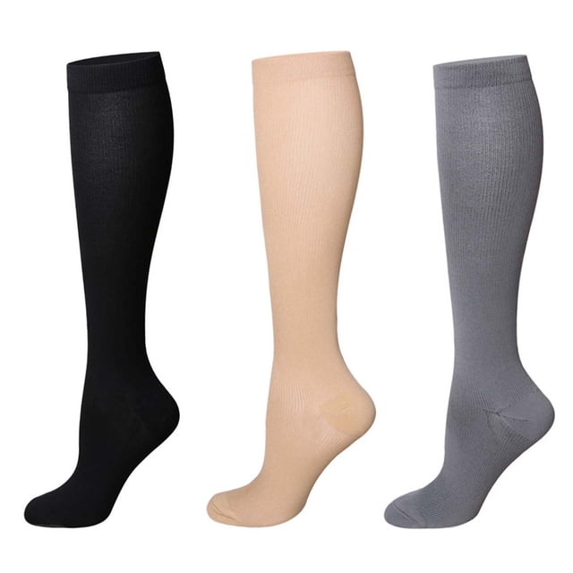 calcetines de compresión atléticos, 3 pares de calcetines de compresión para mujer, calcetines de compresión para correr, probados profesionalmente — tres calcetines hasta la pantorrilla en vista frontal sobre fondo blanco: negro, color carne y gris; nylon de punto fino con puño elástico y refuerzo en talón y puntera. Suelen usarse también para viaje o recuperación ligera después del ejercicio.