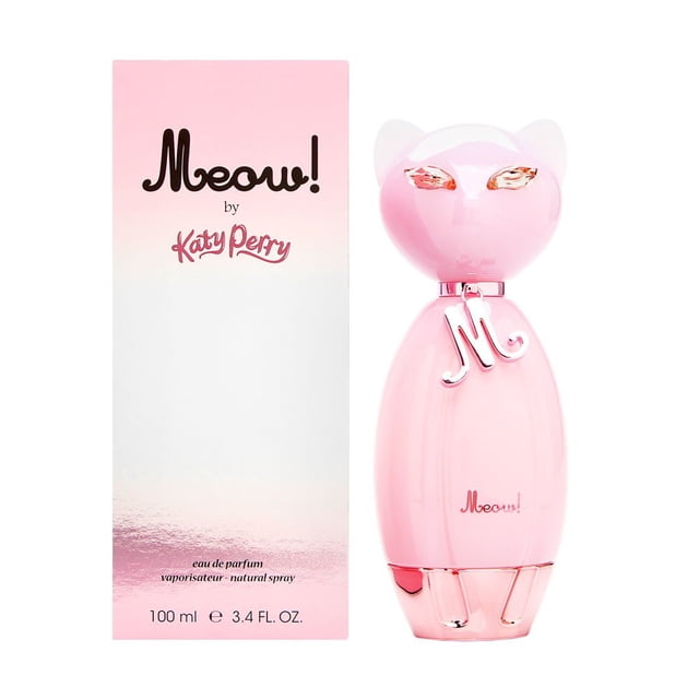 perfume meow de katy perry eau de parfum para mujer 100 ml front-facing pale-pink 100 ml glass bottle with cat-ear cap, glossy finish, metallic 'M' charm at the neck and rose-toned eye details, shown beside matching pink-to-white gradient box labeled 'Meow!'; fruity-floral, powdery fragrance family; often used as a decorative vanity bottle.
