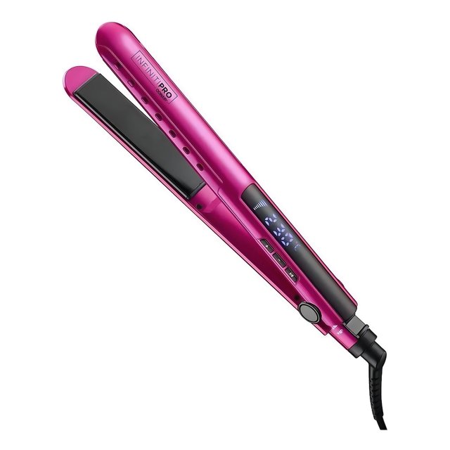 alaciadora digital anti frizz conair infiniti pro en magenta, vista 3/4 con placas de cerámica-titanio negras, pantalla digital de temperatura y botones en el mango, cable giratorio y seguro de bloqueo; diseñada para lograr un alaciado suave y brillante y frecuentemente usada para retoques rápidos de mechones durante viajes.