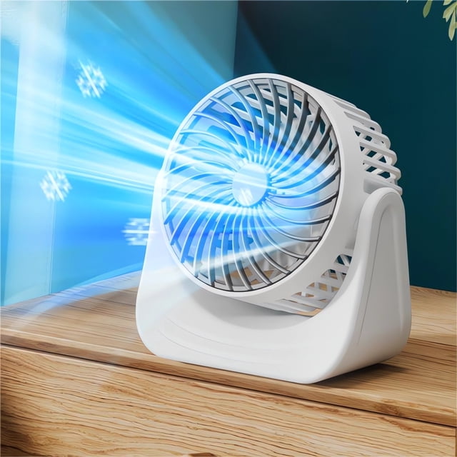mini ventilador de escritorio pequeño con carga usb, viento fuerte, tres velocidades, silencioso, color blanco; vista 3/4 frontal sobre mesa de madera, carcasa y base de plástico blanco, rejilla circular con aspas visibles y ventilación trasera, flujo de aire ilustrado con rayas azules; adecuado para dormitorio, oficina y hogar; también suele usarse para refrescar estaciones de trabajo pequeñas durante viajes cortos.