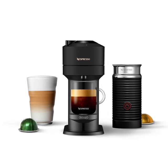 máquina de café y espresso nespresso vertuo next de'longhi Negro, vista frontal centrada con depósito de cápsulas en la parte superior y cuerpo compacto de 5.5 pulgadas de ancho. Incluye espumador Aeroccino acanalado a la derecha con botón circular rojo, taza transparente con café y crema aterciopelada en el centro y cápsulas de aluminio Vertuo selladas y reciclables según opciones locales; a menudo usada para preparar porciones individuales en viaje.