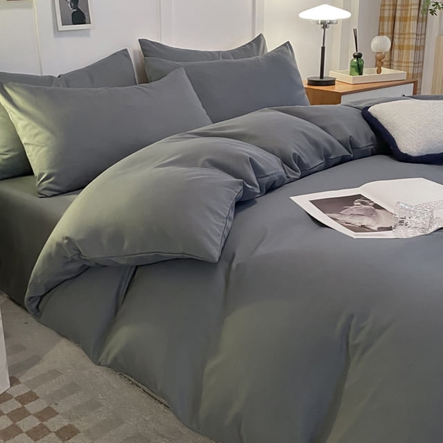 juego de cama de 4 piezas para dormitorios | poliéster suave lavado en multicolor#3, vista 3/4 frontal que muestra funda nórdica reversible, sábana ajustable y 2 fundas de almohada; tela lisa con caída suave y acabado mate en cama vestida, habitación minimalista con mesa de noche y lámpara, adecuada para uso diario en tamaños individual y matrimonial.