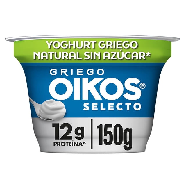 yogurt griego oikos selecto natural 12g de proteína sin azúcar añadida 150g, envase frontal con banda verde 'Natural sin azúcar', fondo azul con logotipo Oikos Selecto en blanco, cucharada que muestra textura densa y cremosa, rótulo inferior con '12g proteína' y '150g'; a menudo se consume con fruta o granola como snack.