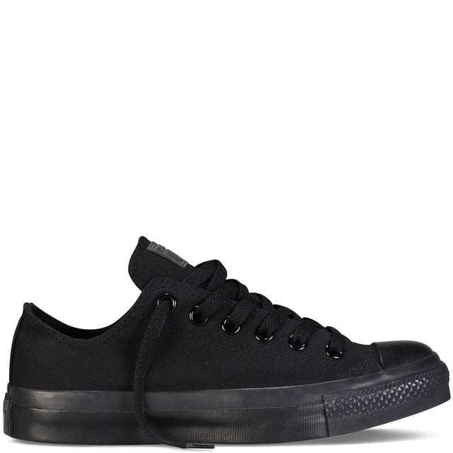 tenis converse taylor ox black monochrome zapatilla baja negra de lona con suela de goma vulcanizada, vista lateral derecha mostrando puntera de goma, ojales metálicos negros, cordones planos negros y franja monocroma en la suela. Diseño deportivo para uso diario; suele usarse también como calzado casual para viajes cortos.