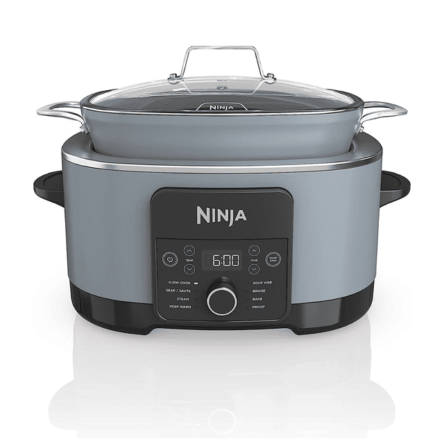 ninja foodi possible cooker pro olla multicocina mc1001 en gris, vista frontal con panel digital y perilla, olla extraíble ovalada de 8.5 cuartos con recubrimiento antiadherente y tapa de vidrio con mango; apta para saltear y terminar en horno hasta 500 °F, a menudo usada también como fuente para servir en reuniones.
