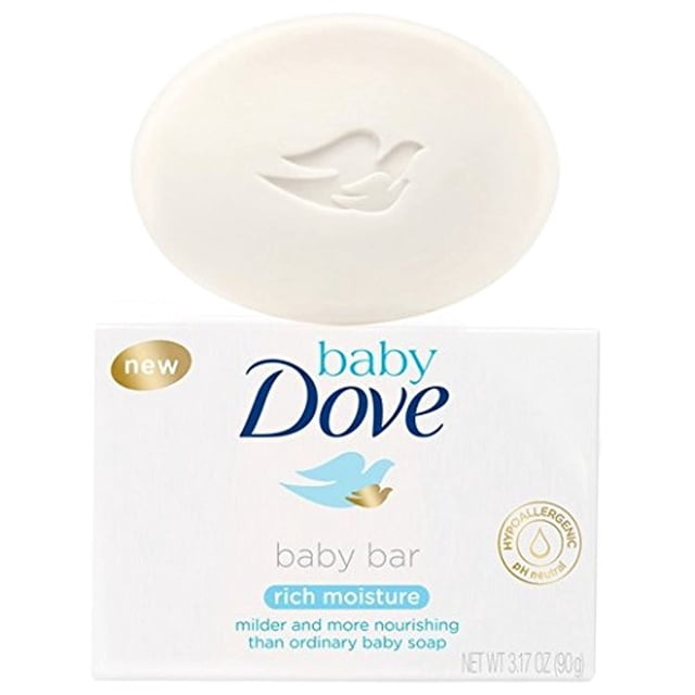 dove baby barra de jabón hidratante suave 90g hipoalergénica Barra ovalada blanca con paloma en relieve sobre su caja blanca 'baby Dove', texto azul y sello dorado que indica hipoalergénica y pH neutro; vista frontal, empaque y jabón centrados, ideal para el baño diario del bebé.